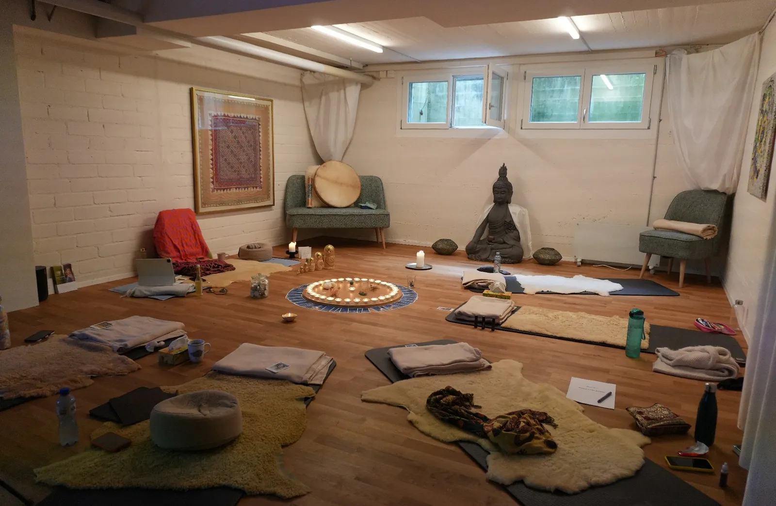 Seminarraum in Oensingen mit Yoga-Matten, Schaffellen, Buddha und Kerzen-Mandala in der Mitte